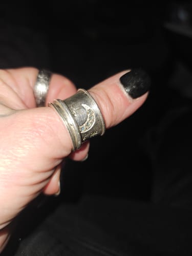 Reviewer showing the wide Stars and Moon Fidget Ring being worn on their thumb.