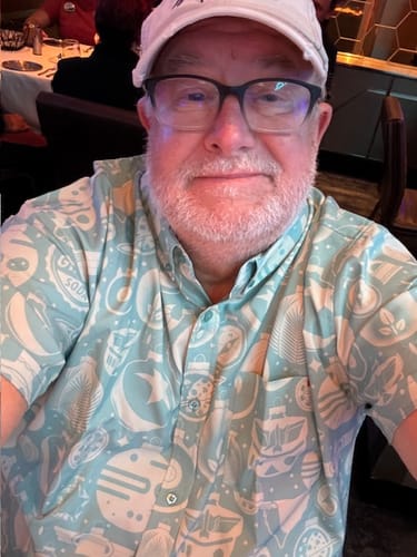 Reviewer in a white cap wearing the light blue patterned "Holiday Hangin'" short sleeve shirt.