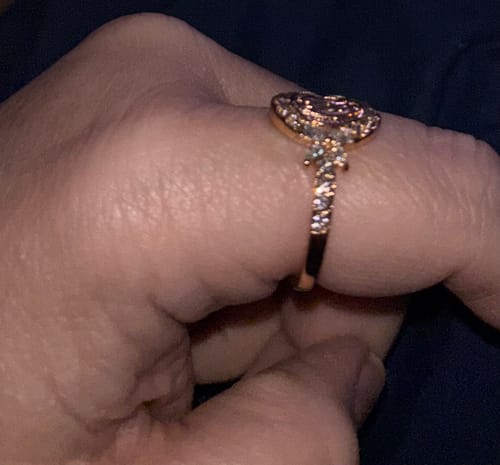 Customer's hand showing the side profile of the gold Virgin Mary Emblem Ring with its sparkling crystal band.
