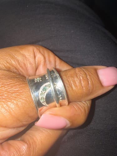 Reviewer wearing the wide silver Aquamarine Stars and Moon Fidget Ring on their thumb.