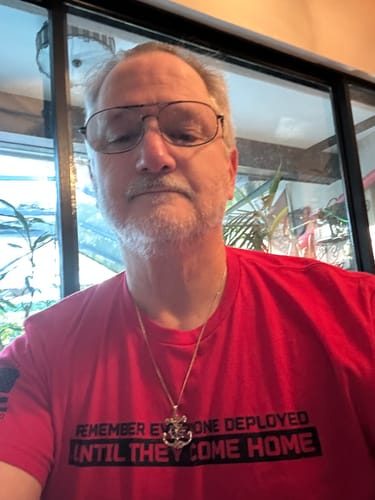 Reviewer wearing a red, short-sleeve t-shirt with black text on the chest.