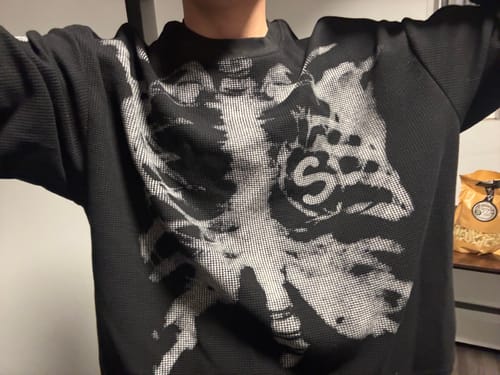 Reviewer wearing the Skeleton Graphic Waffle Sweatshirt, showing its black waffle texture and white skeleton print.