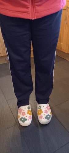 Reviewer wearing the white Livia Flower Slippers with a colorful floral pattern.