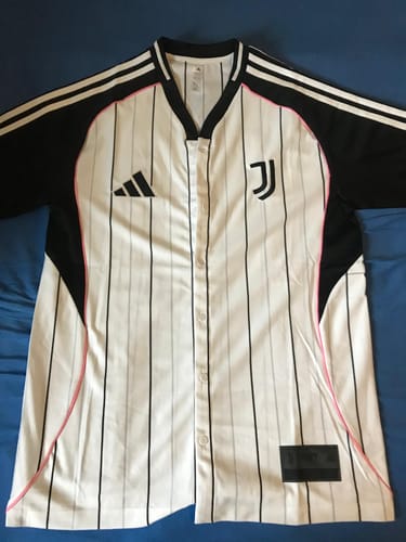 Cliente mostra la maglia da baseball della Juventus, bianca a righe nere con maniche nere e dettagli rosa.