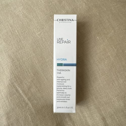 お客様のCHRISTINA LINE REPAIR HYDRA THERASKIN +HAの箱。布の上に置かれています。