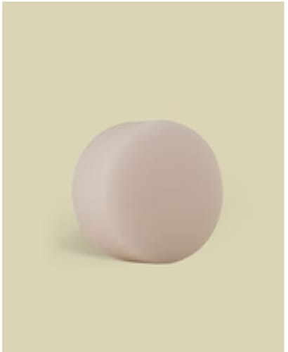 Customer's pink, round Hair Reviver solid shampoo bar on a light background.