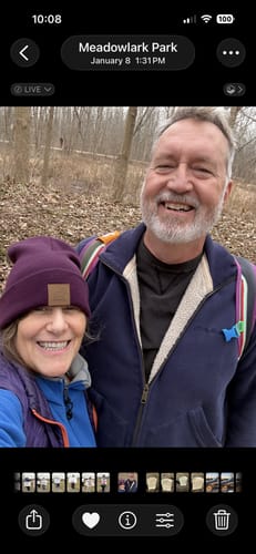 A smiling reviewer wearing the purple Baylor Beanie outdoors with another person.