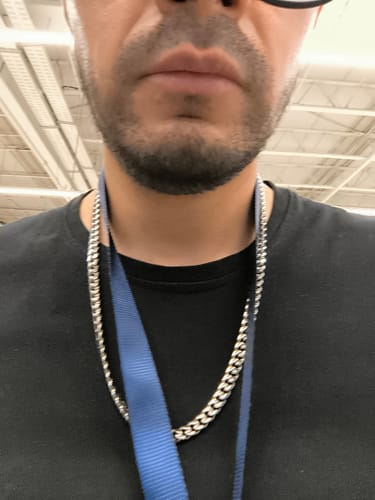 Primer plano de un cliente luciendo la Cadena Cuban Link 8mm plateada sobre una camiseta negra.