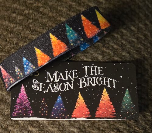 Customer's 'Make the Season Bright Bracelet' with a colorful tree design, shown with its matching card.