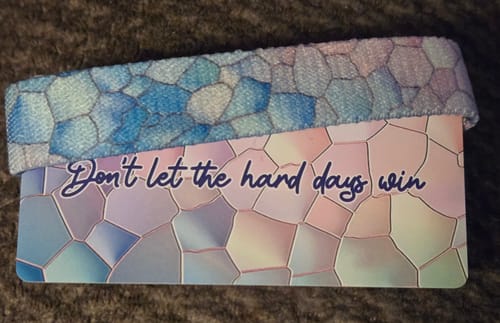 Customer's 'Don't Let the Hard Days Win Bracelet' with a blue mosaic pattern, shown on its backing card.