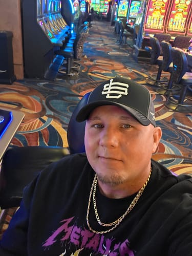 Reviewer wearing the black Smoke Stack Trucker Cap in a casino.