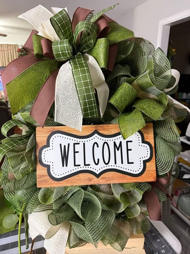 Customer's completed wreath made with the Damons Stash Sign & Ribbon Bundle, featuring a 'WELCOME' sign and a large bow.