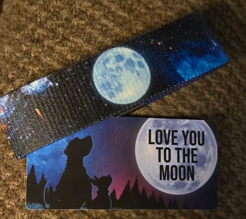 Customer's Love You To The Moon Bracelet with a night sky design, shown next to its matching card with dog silhouettes.