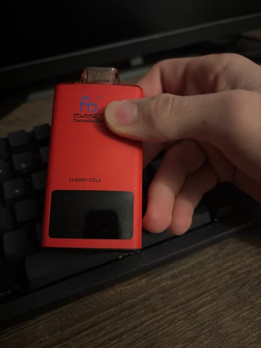 Customer holding the red RandM Tornado 35000 vape in the Cherry Cola flavor.