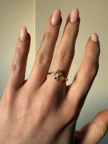 Close-up of a reviewer's hand wearing the Leesha Birthstone Ring with yellow and clear stones.