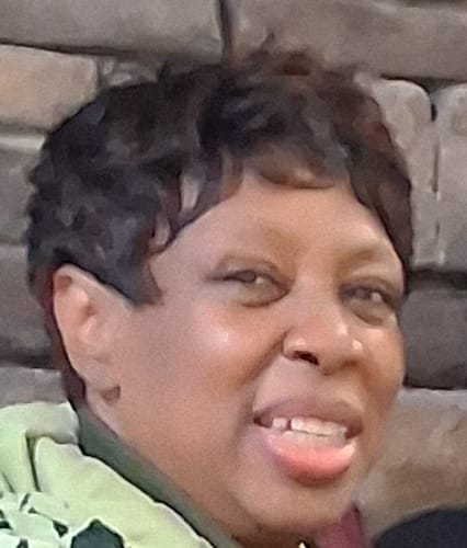 Close-up of a smiling customer wearing the short, dark Motown Tress VOGUE wig.