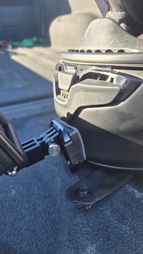 Close-up of a reviewer's Shoei RF-1400 Camera Mount fitted securely on the chin of a black helmet.