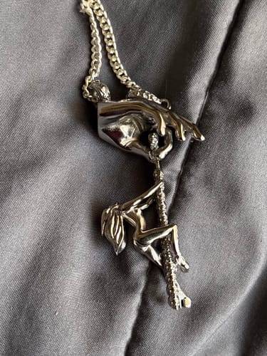 Customer's silver DANCING WITH DEATH PENDANT featuring a figure pole dancing on a skeletal pole held by a hand.