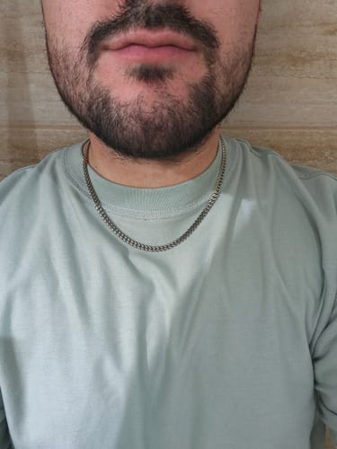 Primer plano del cliente usando la Cadena Miami Cuban plateada en su cuello.