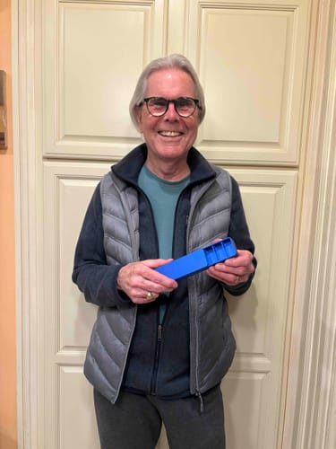 Reviewer smiling while holding an open, blue pill case from the 3-Pack Bundle.