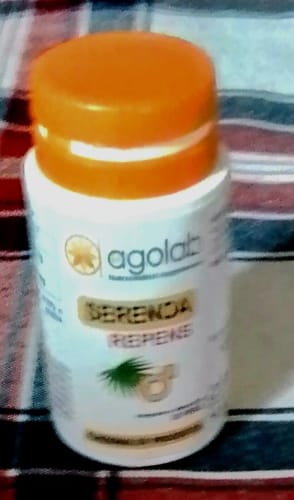 Vista sfocata del recensore del flacone di Serenoa Repens, bianco con tappo arancione.