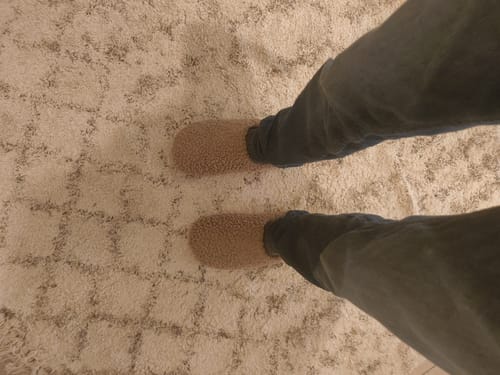 לקוח/ה נועל/ת את נעלי הבית הפרוותיות Lamb Grey, מבט מלמעלה.