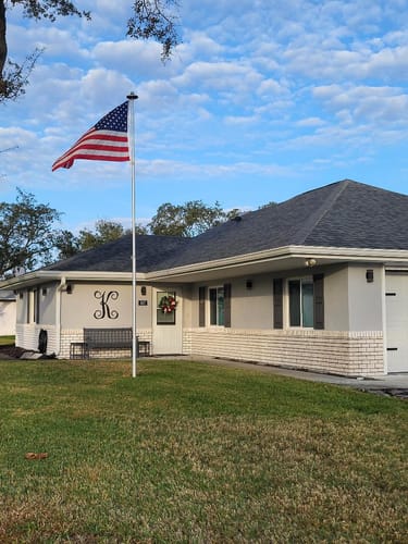 Customer's Heavy Duty American Nylon Flag flying on a flagpole in front of a single-story house.