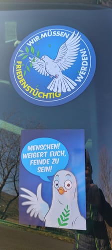 Nahaufnahme des runden 'Friedenstütig werden'-Aufklebers eines Kunden auf einem Autofenster.