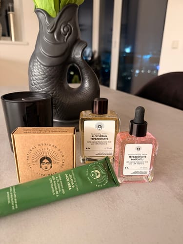 Customer's Skin Refining Routine products, including a green tube and two glass bottles, displayed on a table.