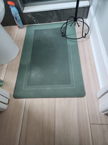 Customer's dark green rectangular Magic Mat on a bathroom floor next to a shower.