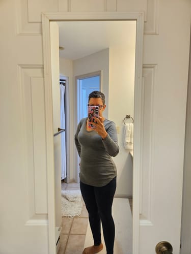 Reviewer taking a mirror selfie wearing the deep navy Piper Pocket Leggings with a grey tunic.