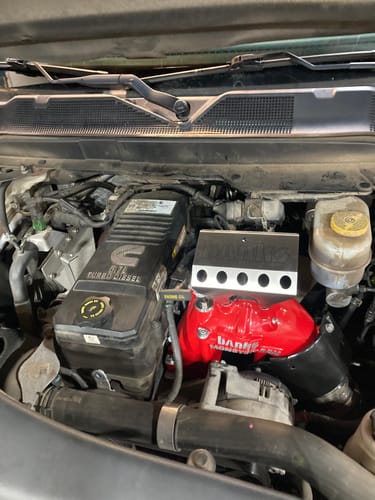 Customer's bright red Monster-Ram Intake installed in the engine bay of a Cummins diesel truck.