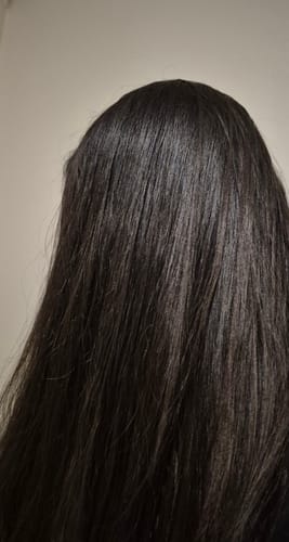 Clienta mostrando su cabello liso y brillante después de usar el tratamiento Hidratox.