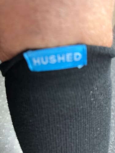 Close-up of a reviewer's leg wearing the black Performance Eucalyptus Compression Socks, showing the blue tag on the cuff.
