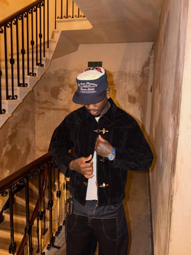 Reviewer wearing the black Suede Lapel Bomber Jacket with unique metal toggle buttons on a staircase.