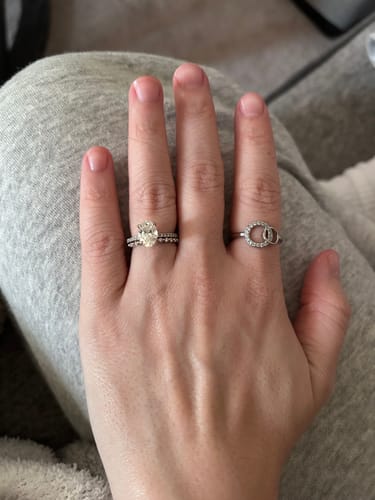 Reviewer's hand wearing the silver-colored Forever Linked Ring on their middle finger next to a wedding band.