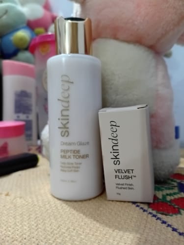 Customer's box for VELVET FLUSH Lip+Cheek Blush, shown with a bottle of the brand's milk toner.