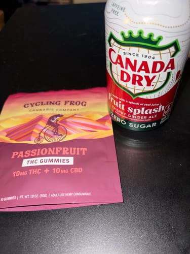 Customer's pouch of Passionfruit Gummies sitting on a dark table next to a can of ginger ale.