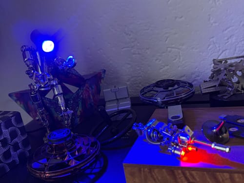Reviewer's assembled Terminator M model with a glowing blue light, displayed on a shelf with other models.