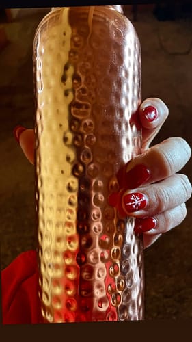 Customer holding the hand-hammered Pure Copper Water Bottle.