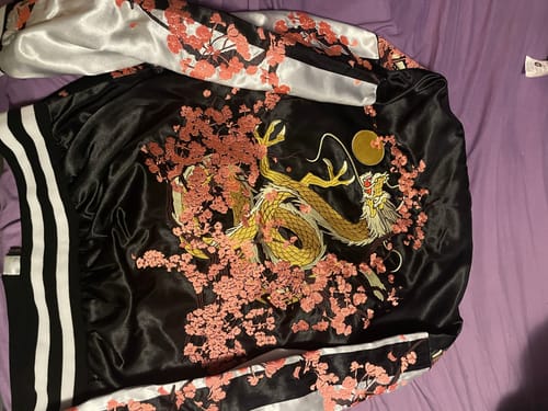 Reviewer's Mikamo Neru Scarzan Jacket laid out, showing the embroidered golden dragon and pink cherry blossoms on the back.