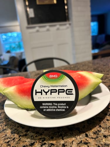 Customer's can of HYPPE Chewy Watermelon pouches on a white plate with two fresh watermelon slices.