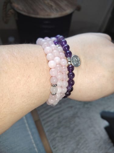 Cliente montrant son bracelet Améthyste et Quartz Rose enroulé plusieurs fois au poignet.