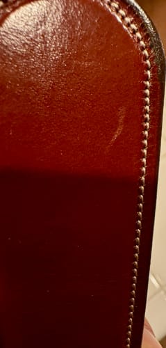 Close-up of the reviewer's brown leather Everyday belt, showing a slight scratch and detailed stitching.