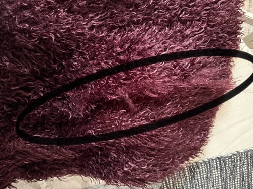 Close-up of the Faux Fur Plush Long Coat, highlighting a bare patch in the plush material.