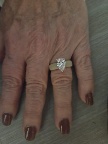 Customer's hand wearing the pear-cut CZ Silicone Ring with a light-colored band.