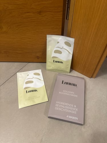 Kunde zeigt die Verpackung der Kollagen Boosting Maske: eine Schachtel und zwei einzelne Beutel.