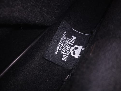 Close-up of the 'Pull The Plug Patches' official merchandise tag inside the reviewer's black hoodie.