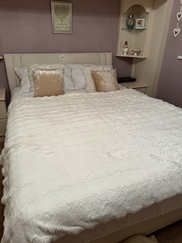 Reviewer's white Nordic Cozy Blanket spread on a bed, showcasing its plush and textured design.