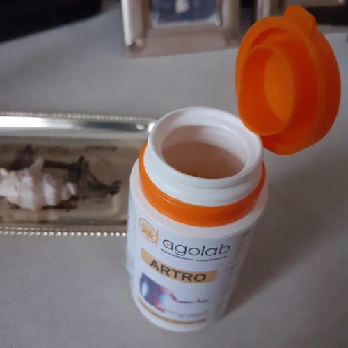 Cliente mostra il flacone di Artro con il suo tappo arancione aperto.